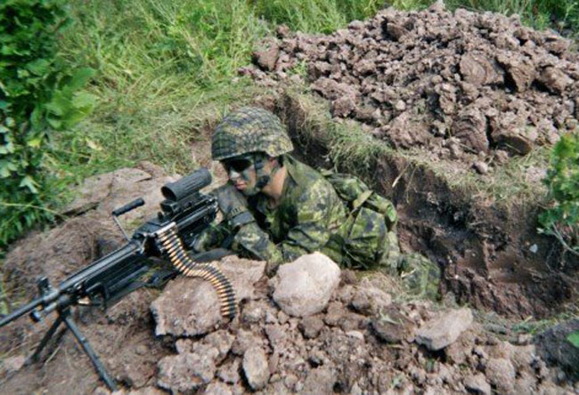 Photo of Anthony Armstrong in bunker with machine gun